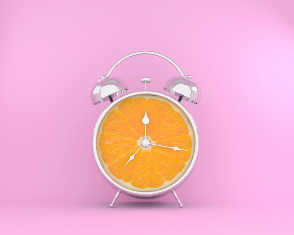 Alarm clock with a orange slice display on a pink background